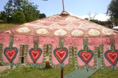 an umbrella with hearts painted on it sitting in the grass