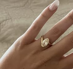 a woman's hand with a ring on it and a diamond in the middle