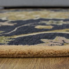 a close up view of a rug on the floor with wood and carpeting in the background