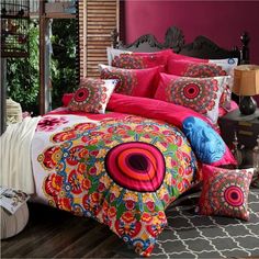 a bed with colorful comforters and pillows on it