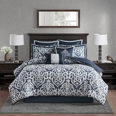 a bed with blue and white comforters in a room