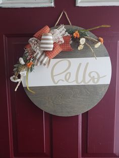 a door hanger with the word hello painted on it, hanging from a red door