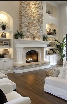 a living room with white furniture and a fireplace