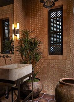 an image of a bathroom setting with tile on the walls and floor, along with potted plants