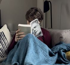 a person sitting on a couch reading a book