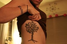 a man with a tree tattoo on his back is holding onto the side of his body