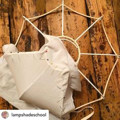 a piece of cloth and some string on a wooden floor with a white bag in the middle