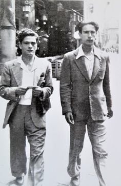 two men in suits walking down the street