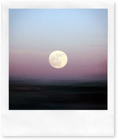 the full moon is seen over an empty field