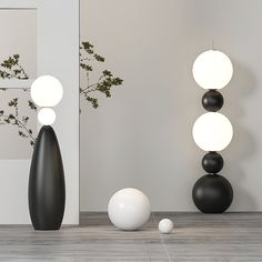 three black and white vases sitting next to each other on the floor in front of a mirror