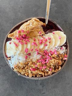 a bowl filled with granola, banana slices and sprinkles on top