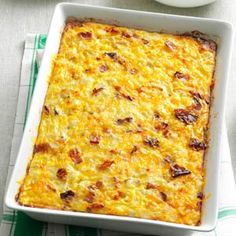 a casserole dish with cheese and bacon in it on a green and white napkin