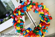 a colorful wreath hanging from the side of a house