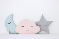 two stars and a cloud are sitting on the shelf next to each other with eyes closed