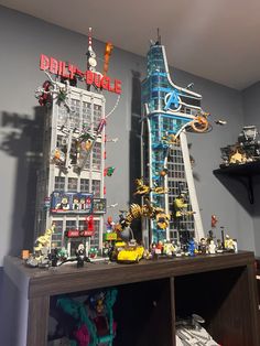 there are many legos on top of the shelf in front of the cityscape