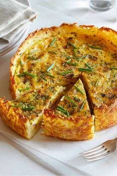 a quiche on a plate with a slice cut out and ready to be eaten