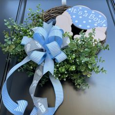 a wreath with a blue bow and it's a boy sign