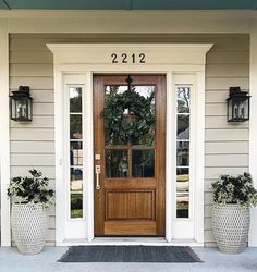 a front door with two planters next to it