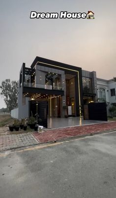 the front view of a modern house with lights on it