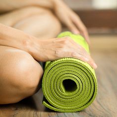 a woman is sitting on the floor with her yoga mat in front of her legs