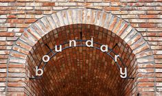 an arched brick wall with the words boundary on it