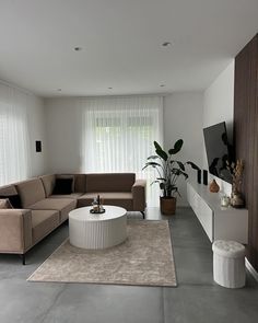 a living room filled with furniture and a flat screen tv on top of a wall