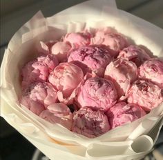 a bouquet of pink flowers in a white paper wrapper