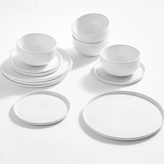 a white table setting with plates and cups