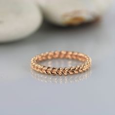 a gold braid ring sitting on top of a table