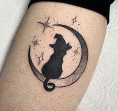 a cat sitting on the moon with stars in it's back leg tattoo design