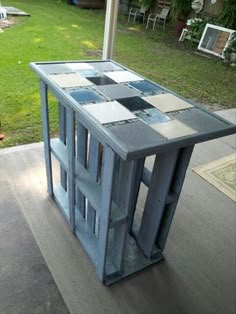 an outdoor table made out of pallet wood and glass blocks is sitting on the porch