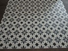 a black and white tile floor with an intricate design on the bottom half of it