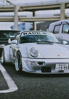 a white porsche parked in front of other cars