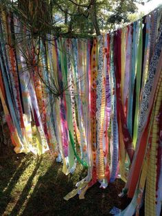 colorful streamers hanging from a tree in the grass