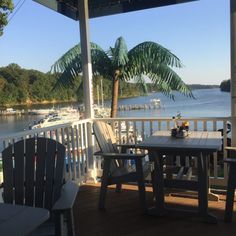 two chairs and a table on a deck overlooking the water