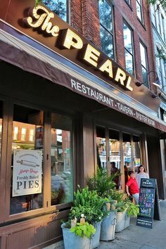 the people are standing outside of the restaurant