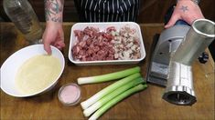 a person is preparing food in a bowl on a wooden table with celery and other ingredients