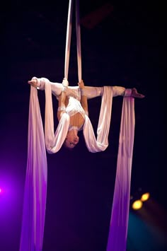 a woman is performing aerial acrobatic tricks