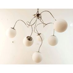 a chandelier with five white balls hanging from it