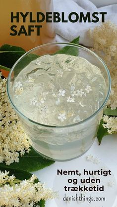 a glass bowl filled with liquid next to flowers