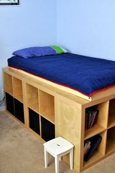 a bed that is made out of some kind of bookcases and has a blue blanket on it