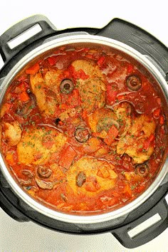 an overhead view of a stew with meat and vegetables in a crock pot on a white surface