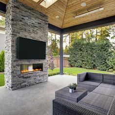 an outdoor living area with fireplace, couch and television