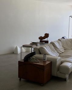 a living room with a couch, table and lamp on the floor in front of it