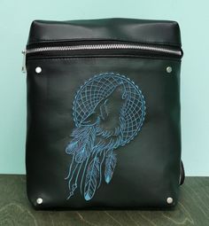 a black leather bag with a drawing of a woman's head and feathers on it