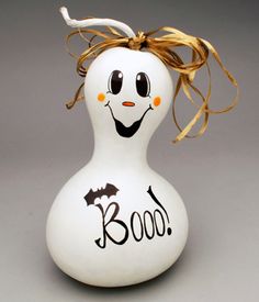 a white ceramic figurine with a bat on it's head that says boo