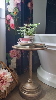 a potted plant sitting on top of a table next to a bath tub