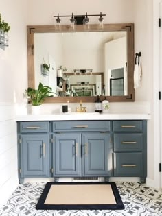 a bathroom with a large mirror and blue cabinetry in the center, along with a rug on the floor