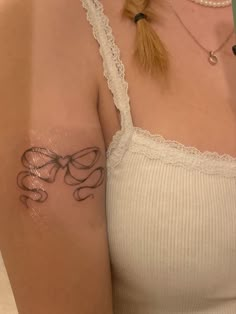 a woman with a bow tattoo on her arm