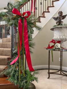 a staircase decorated for christmas with red ribbon